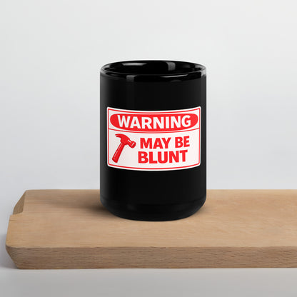 Black glossy 15 oz mug with "Warning May Be Blunt" text, featuring a front view and a sturdy handle.