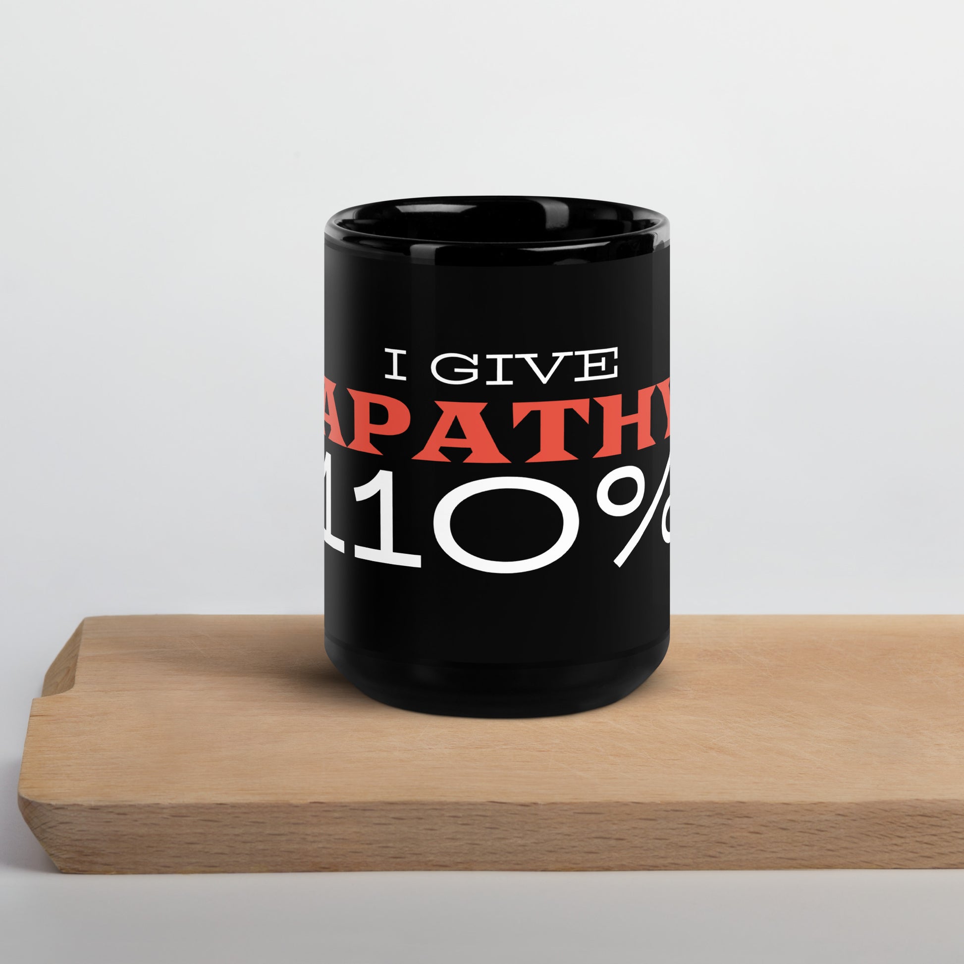 Black glossy 15 oz mug with "I Give Apathy 110%" printed on the front, featuring a sleek wayward.biz design.