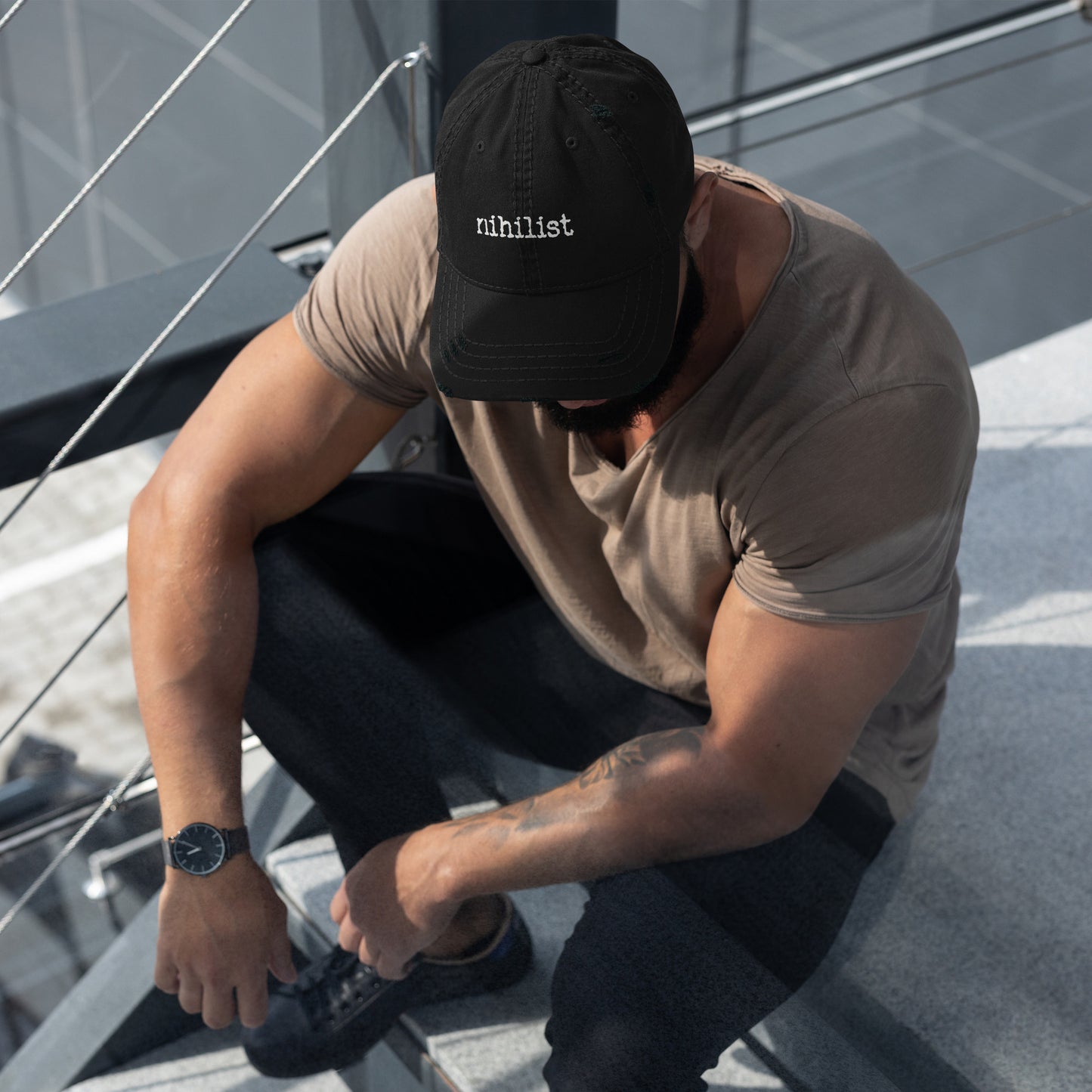 Black distressed Dad Hat with nihilist branding, featuring a casual, worn-in look and adjustable strap from wayward.biz.