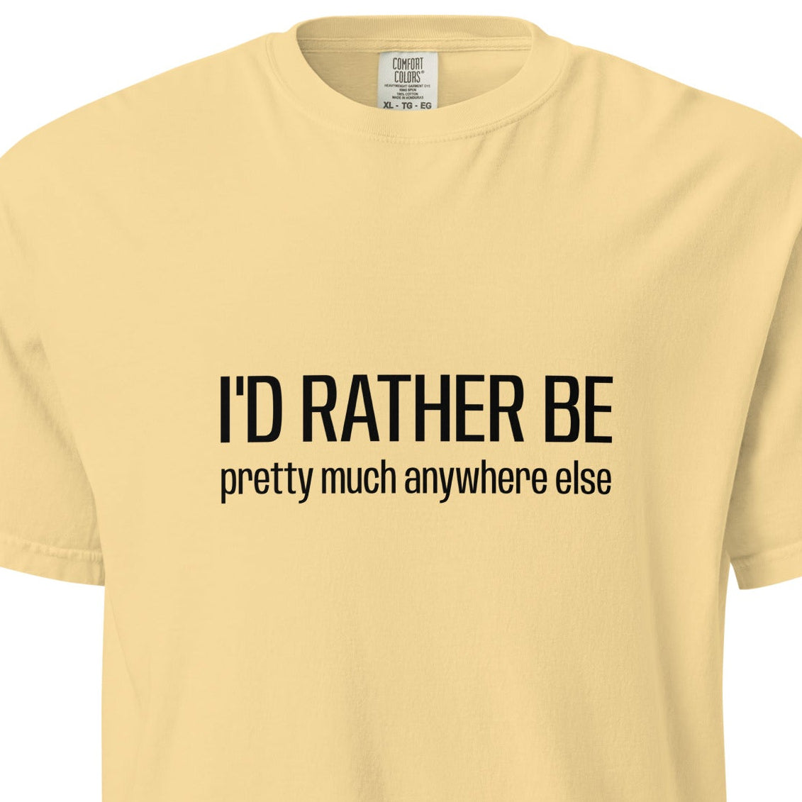 Unisex garment-dyed heavyweight T-shirt with "I'd Rather Be... anywhere else" text on the front, in a buttery color.