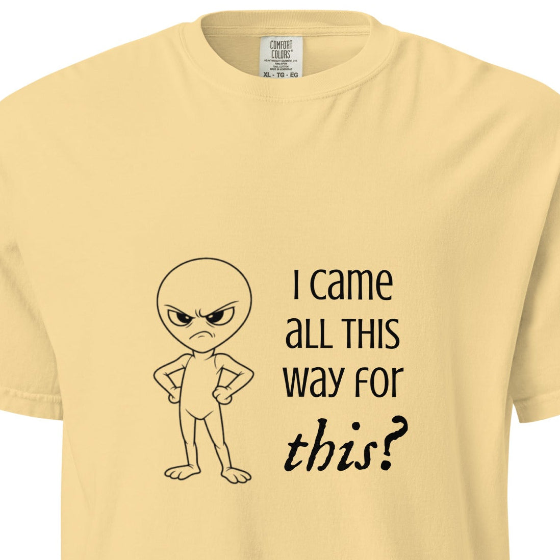 Unisex garment-dyed heavyweight T-shirt featuring an angry alien graphic in butter color, from Wayward.biz.