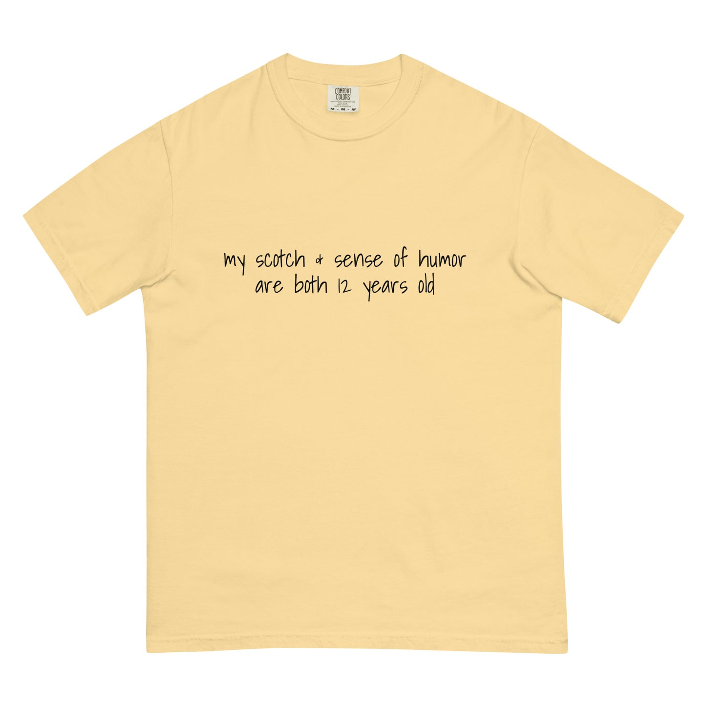 Unisex garment-dyed heavyweight T-shirt with humorous print, 12-year-old Scotch and sense of humor design in butter color.