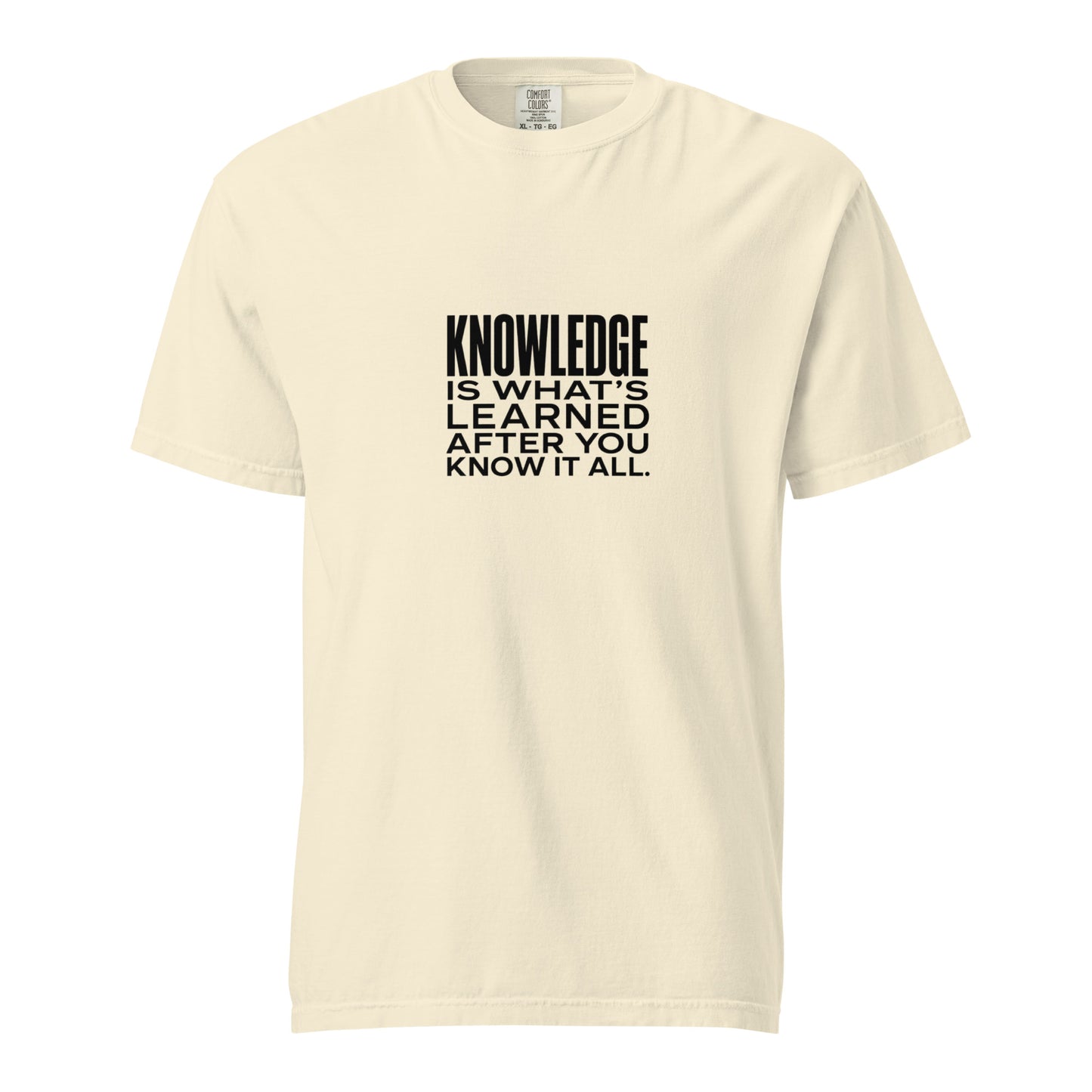 Unisex garment-dyed heavyweight ivory T-shirt with "Knowledge is what's learned after you know it all" printed on front.