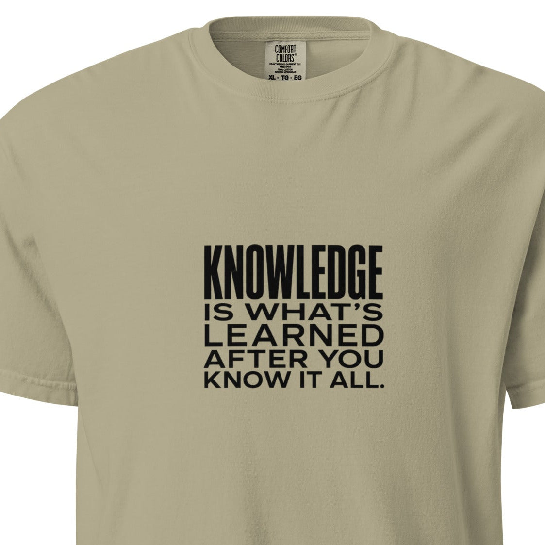 Unisex garment-dyed heavyweight T-shirt with "Knowledge is what's learned after you know it all" print in khaki color.