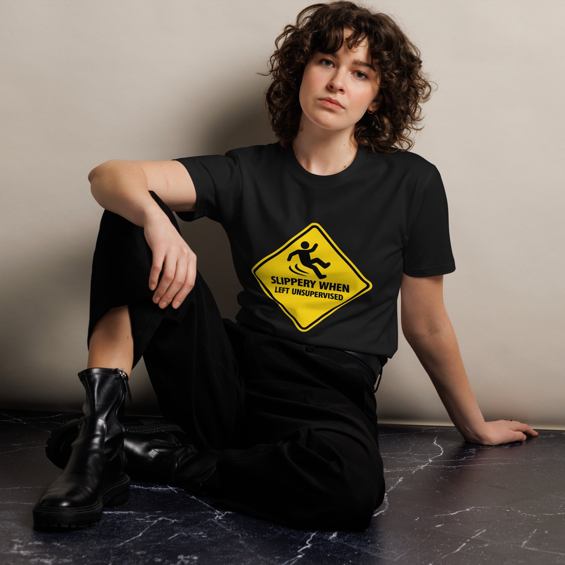 Unisex black premium T-shirt from wayward.biz with "Slippery When Left Unsupervised" graphic on front.